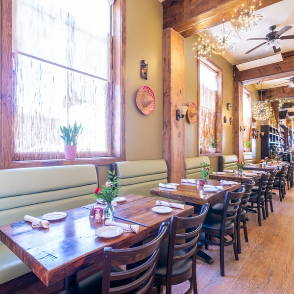 Interior of Gaby's Cafe with rustic wooden tables, green booths, and decorative sombreros on the walls.