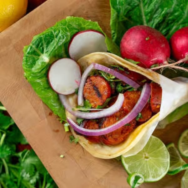 Gaby's Cafe chorizo taco with red onion and cilantro, served with radishes and lime.